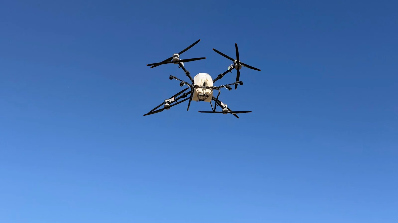 Dron agrícola DJI AGRAS de RMS Geoespacial en vuelo sobre el campo